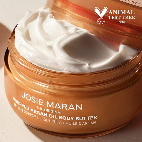 Josie Maran Whipped Argan Oil Body Butter in a clear jar, showcasing soft, creamy texture for hydration